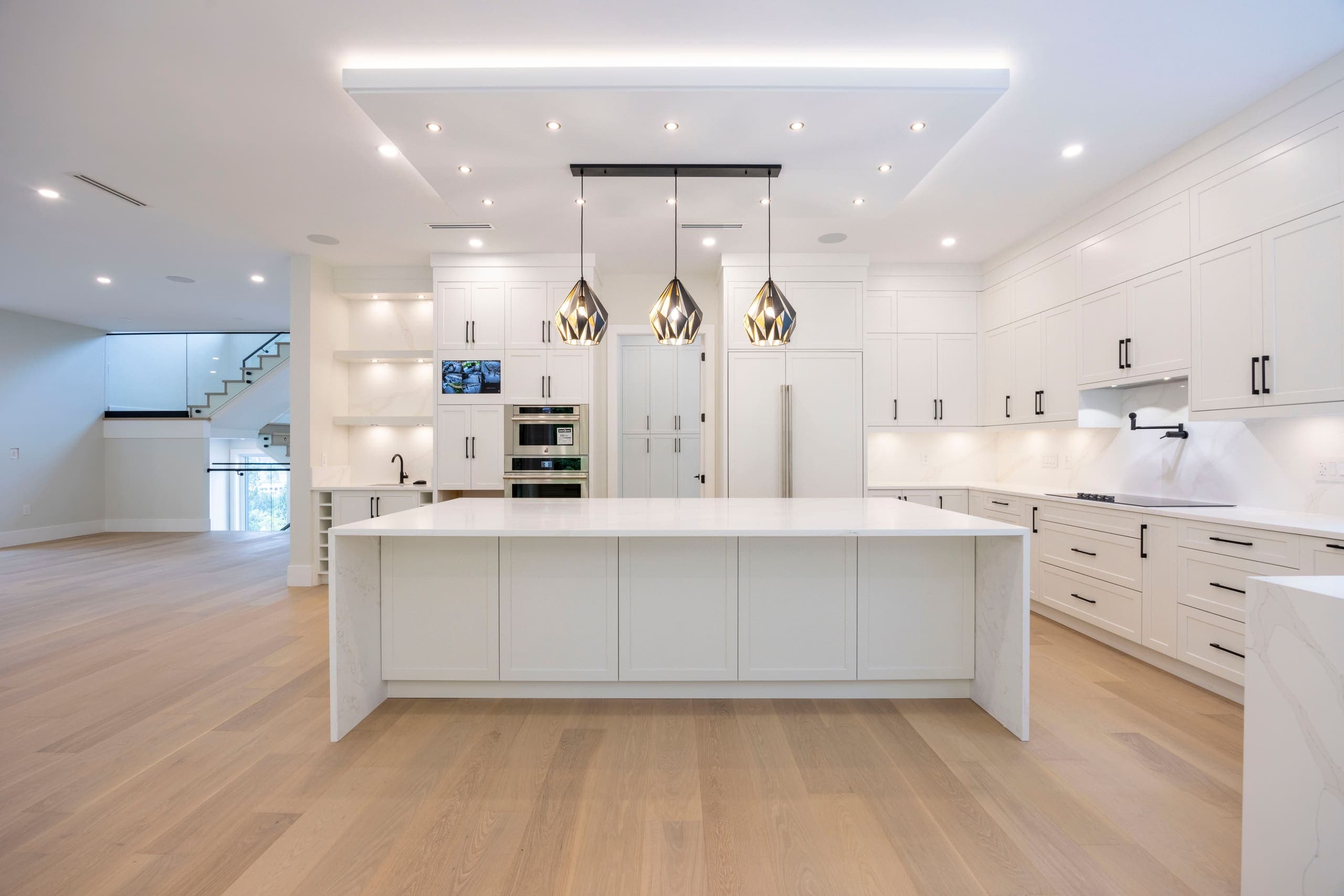 Kitchen with a long island and brass pendants — The Monashee House