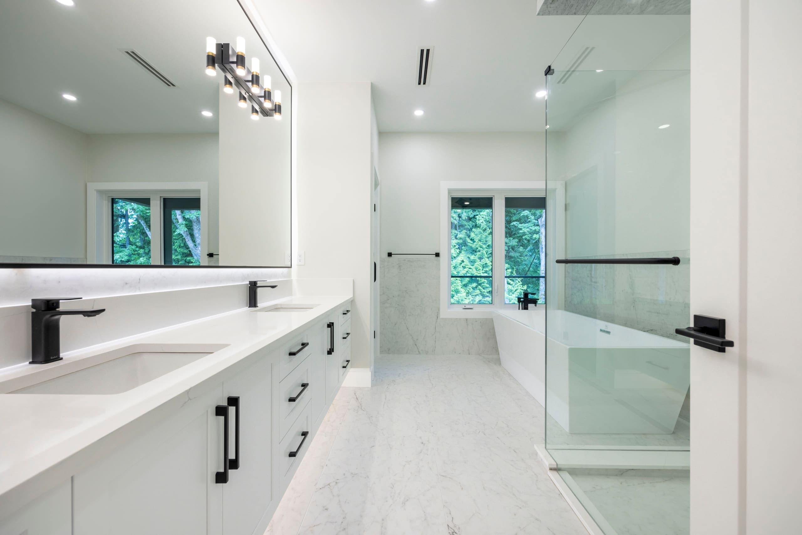 Principal ensuite in marble, twin vanities and a walk-through shower — The Monashee House