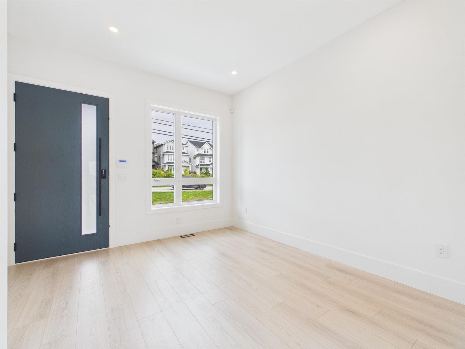 Entry with a blue front door and light through the side window — The Pacific Douglas Duplex