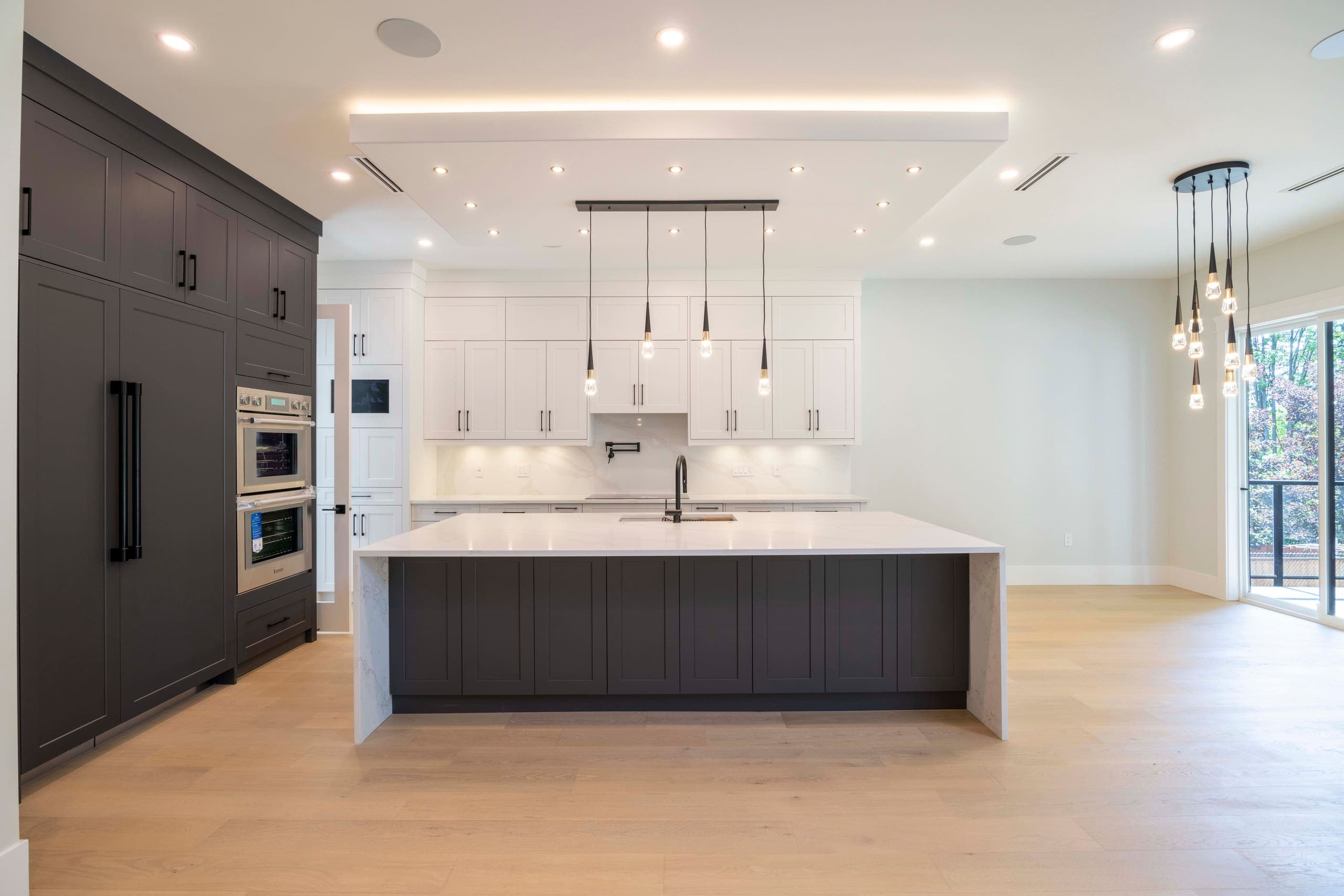 Kitchen with a long island and pendant lighting — The Ridge House